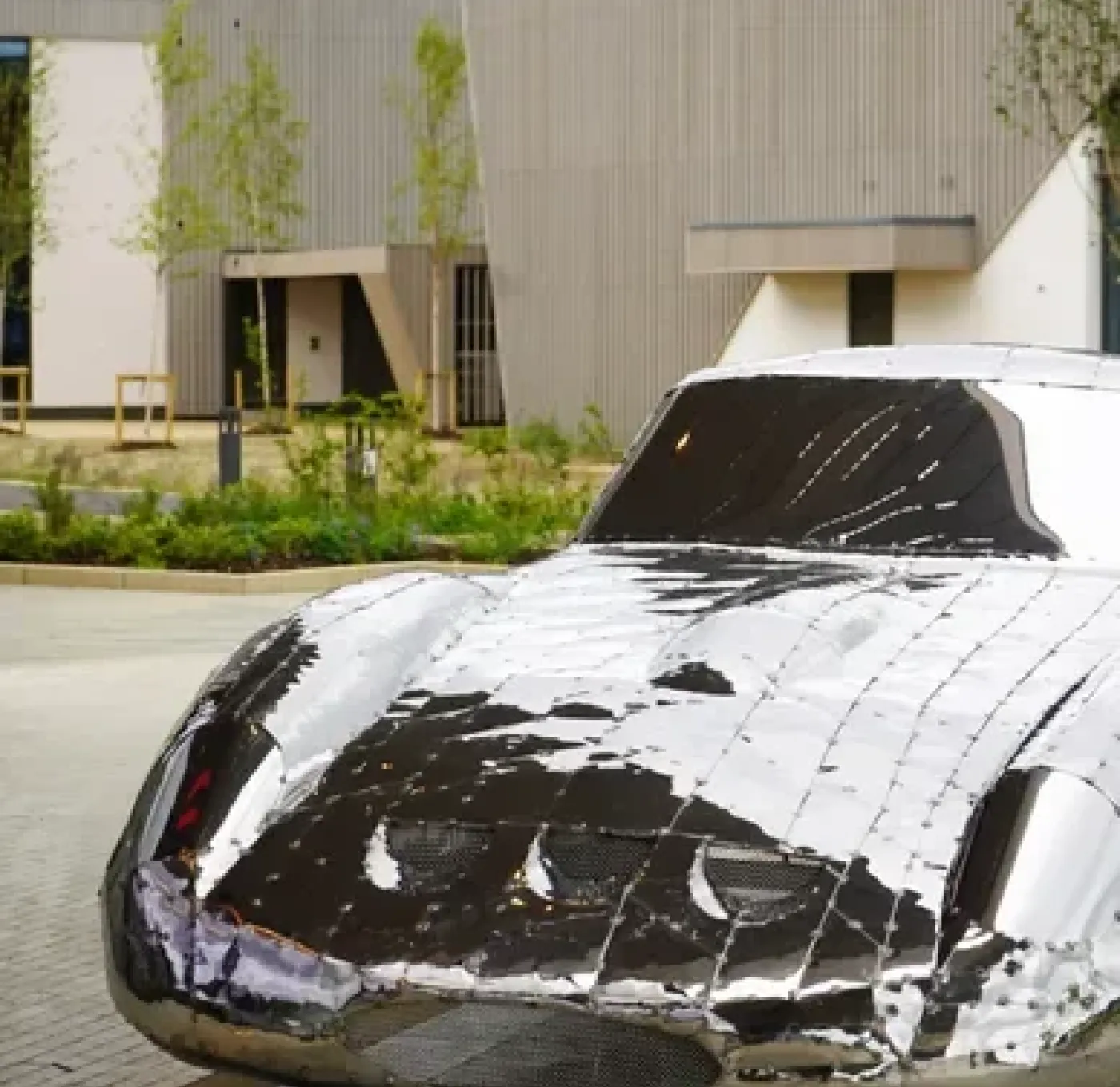 Image of a silver car sculpture in the shape of a classic sports car